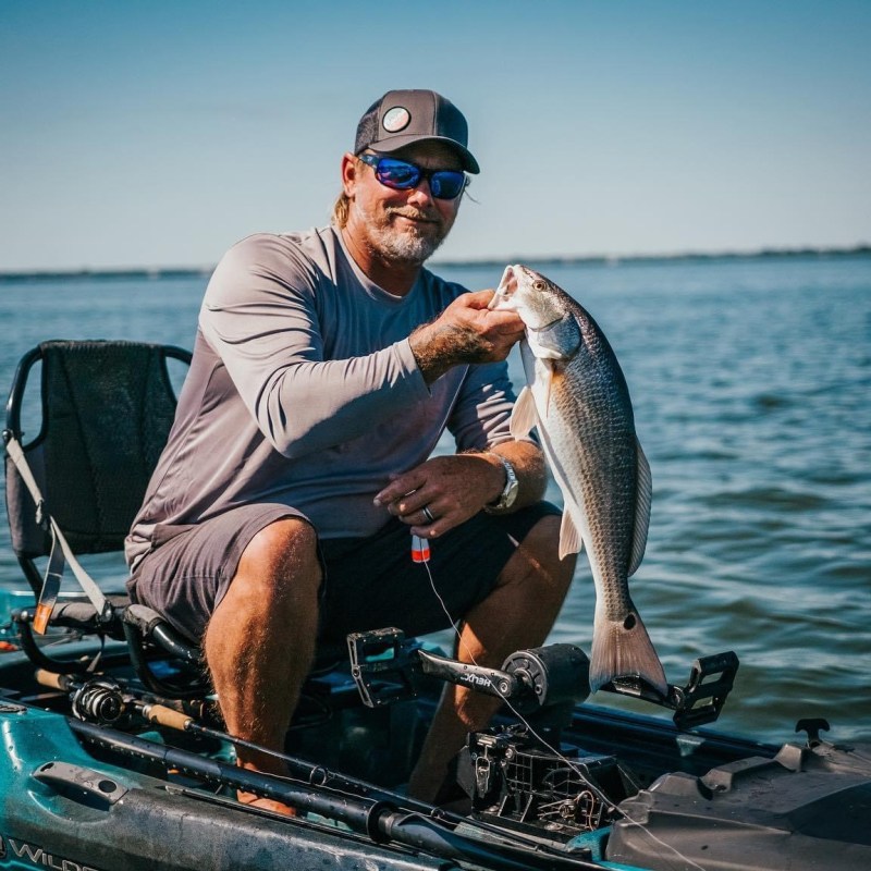 a man riding on the back of a boat in a body of water