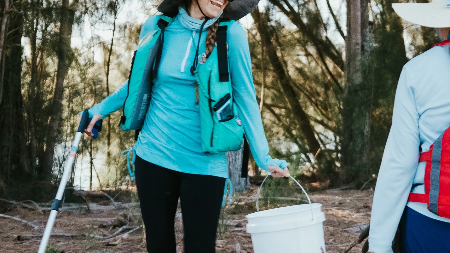 a woman standing next to a forest