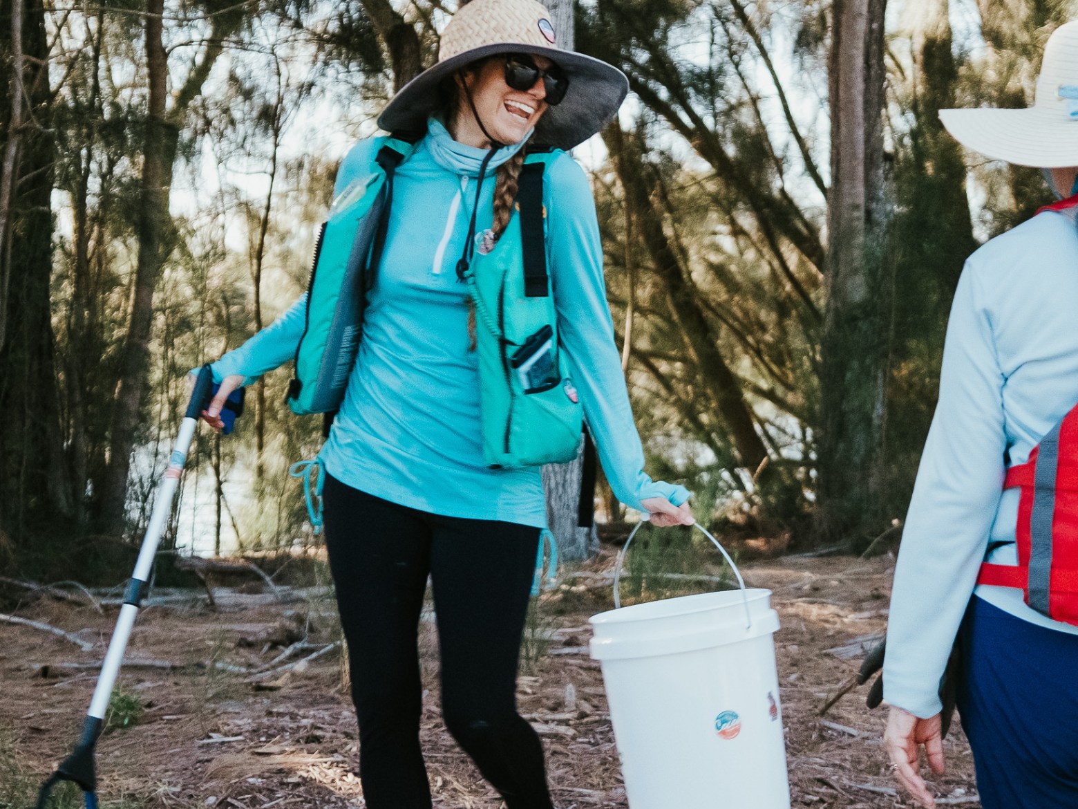 a woman standing next to a forest