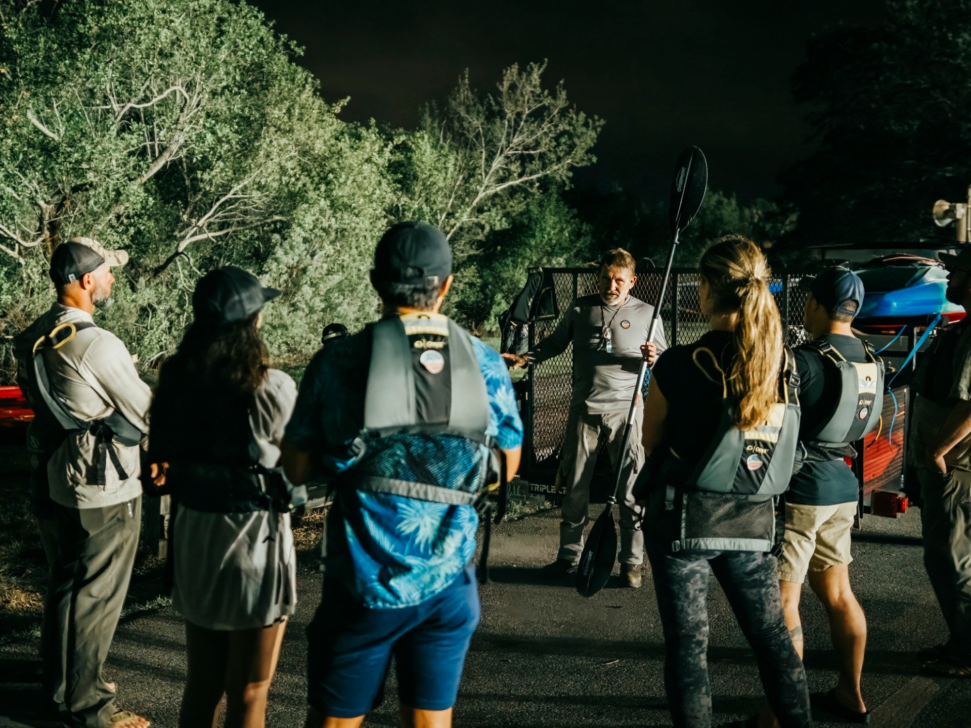 a group of people standing in a parking lot