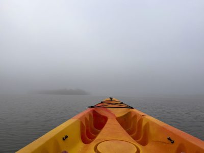a boat sitting on top of a beach next to a body of water