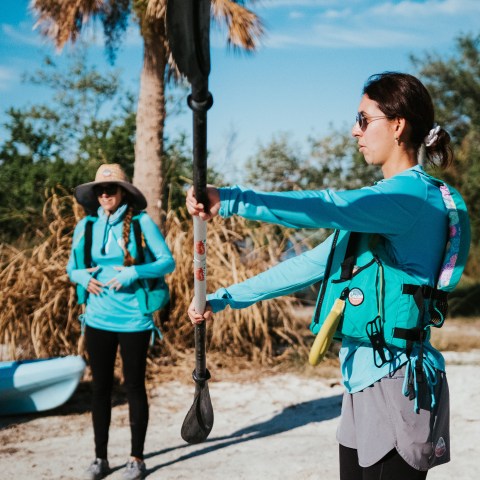 a group of people standing next to a palm tree