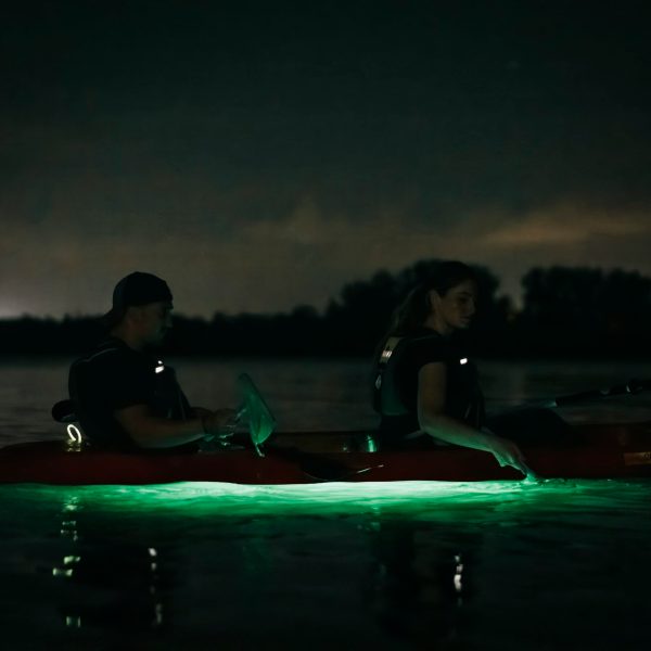 a man sitting next to a body of water