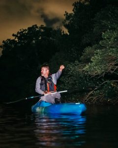 a man riding on the back of a boat in the water