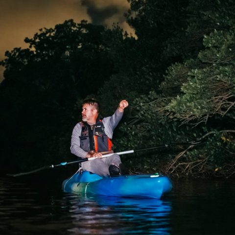 a man riding on the back of a boat in the water