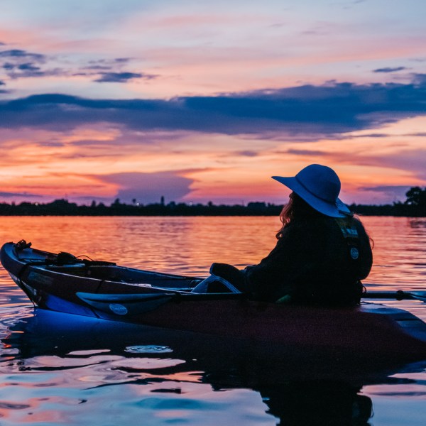 a person sitting in a boat on a body of water