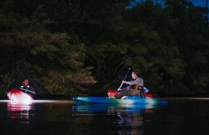 a group of people riding on the back of a boat in the water