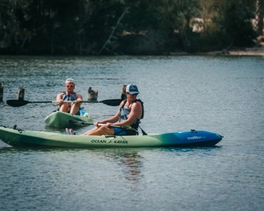 a group of people riding on the back of a boat in the water