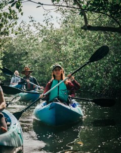a group of people riding on the back of a boat in the water
