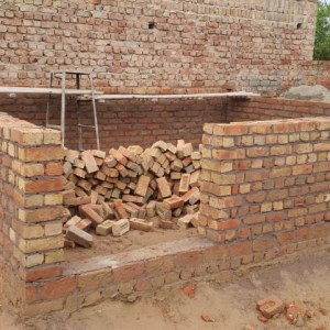 a pile of dirt in front of a brick wall