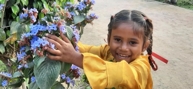 a little boy holding a flower