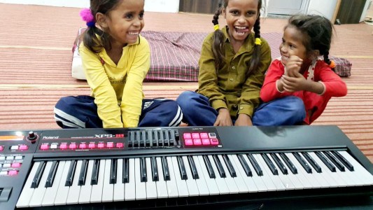 a group of people sitting at a piano