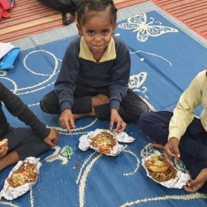 a group of people sitting at a table holding a baby