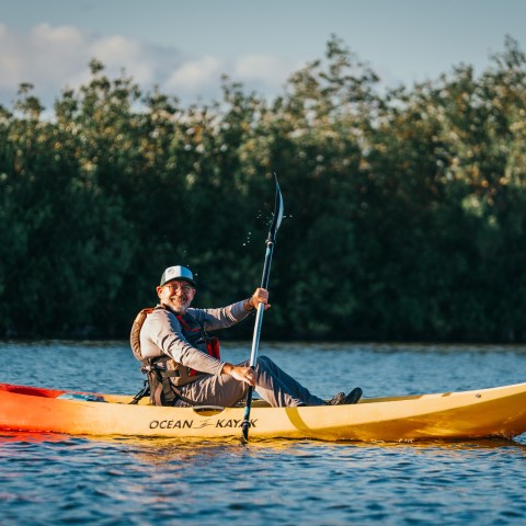 a man riding on the back of a boat in the water