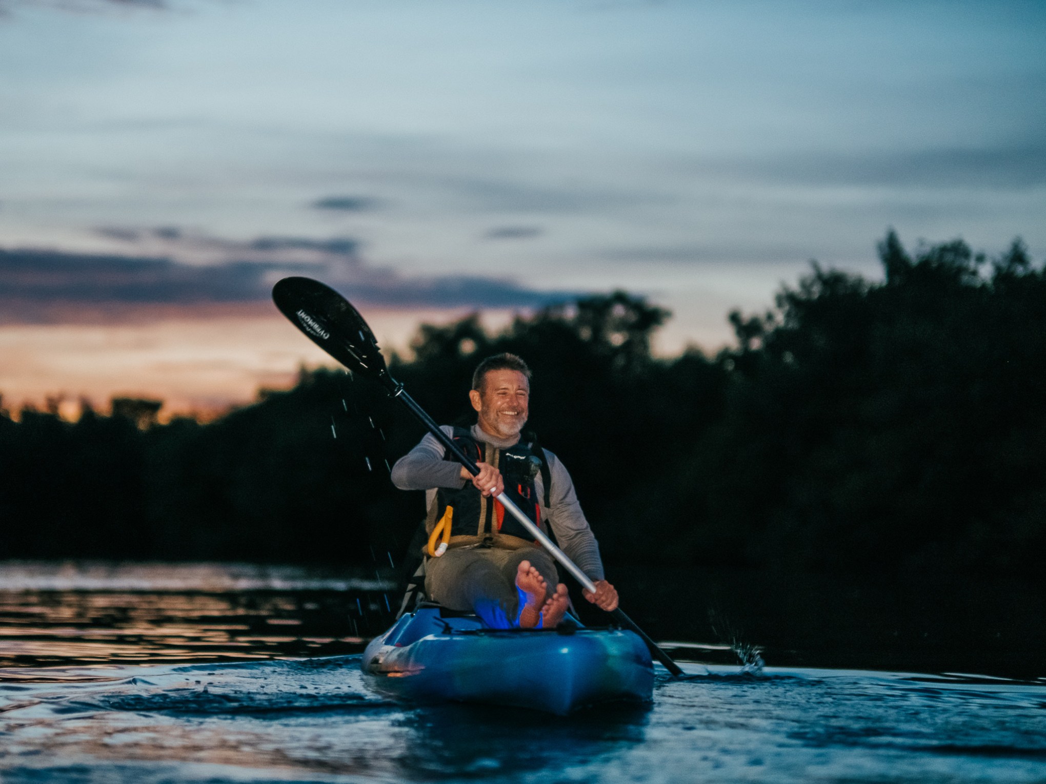 a man riding on the back of a boat in a body of water
