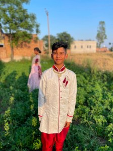 a man wearing a suit and tie standing in a field