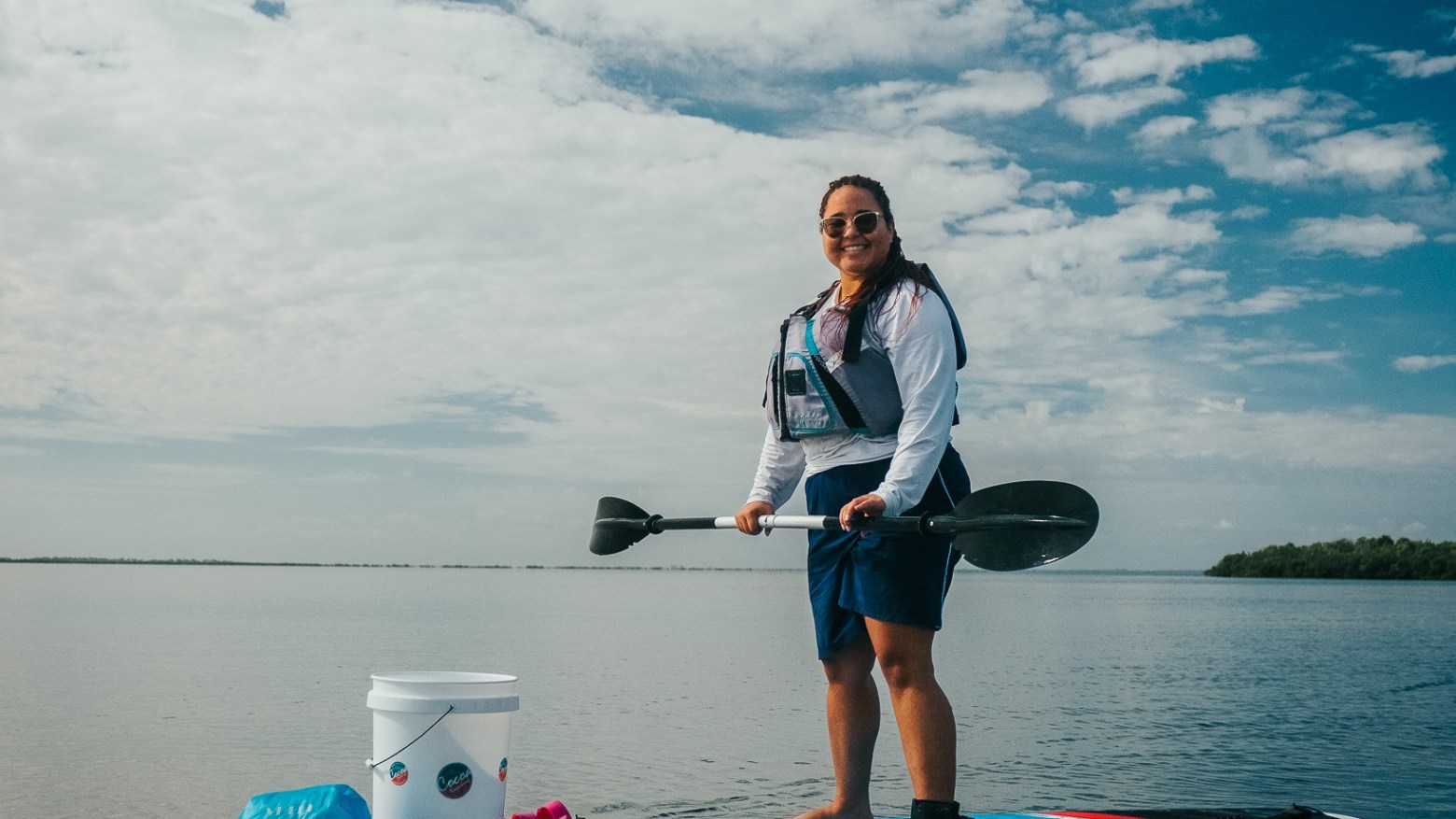 a man and woman riding on the back of a boat in the water