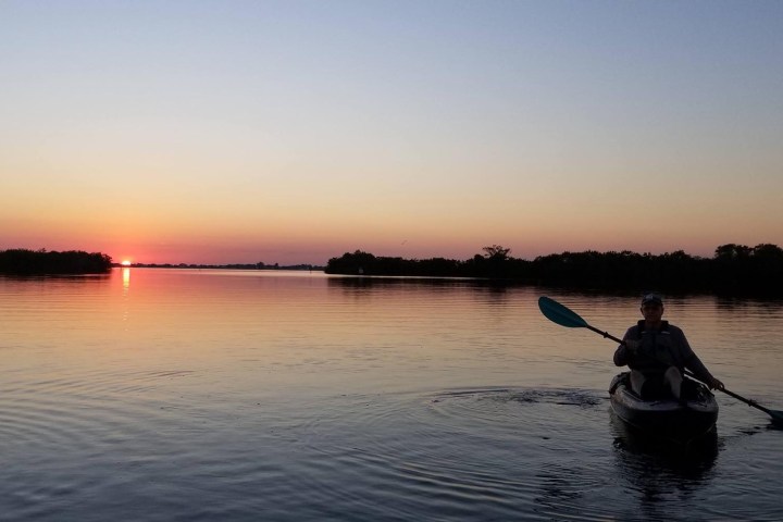 a man standing next to a body of water