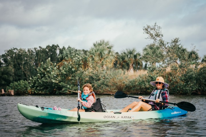 a group of people riding on the back of a boat in the water