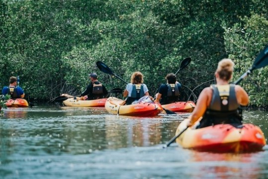 a group of people rowing a boat in the water