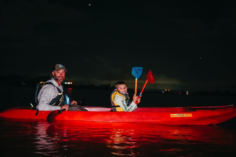 a man riding on the back of a boat in the water