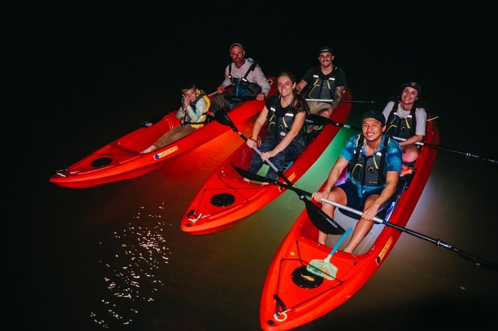 a group of men riding on the back of a boat
