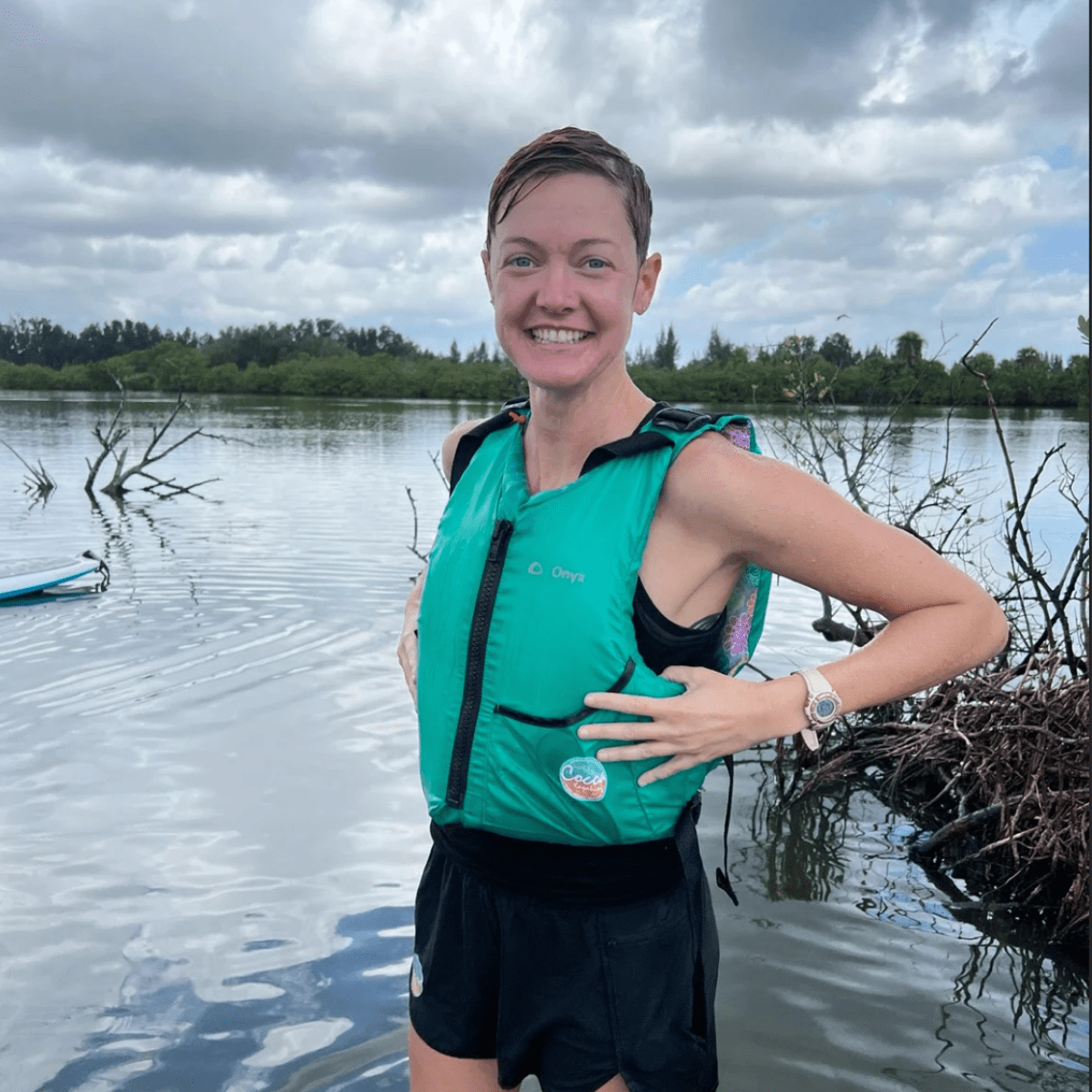 a woman standing next to a body of water